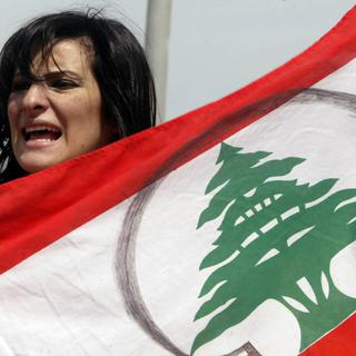 Une femme tient le drapeau du Liban à l'occasion d'une manifestation. [Ramzi Haidar]