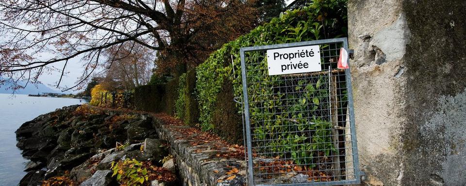 Une barriere annonce l'interdiction de passage le long du bord du Lac Leman ce mercredi 24 novembre 2010 a La Tour de Peilz. [Keystone - Jean-Christophe Bott]