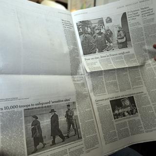 Un Pakistanais lit l'édition international du "New York Times" du 14 janvier 2015 où du blanc remplace l'article consacré au massacre de "Charlie Hebdo". [Aamir Qureshi]