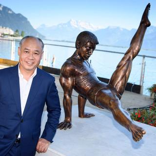 Le gymnaste Li Ning, triple champion olympique et double champion du monde, pose auprès de sa statue sur les quais de Montreux.
Laurent Gillieron
Keystone [Keystone - Laurent Gillieron]