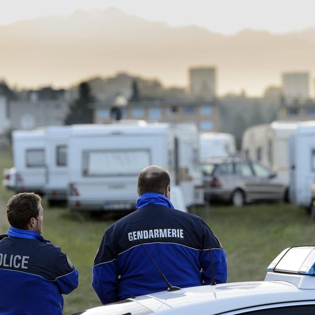 Des caravanes de gens du voyage stationnées illégalement s'en vont sous l'oeil de la police vaudoise. [Keystone - Laurent Gillieron]