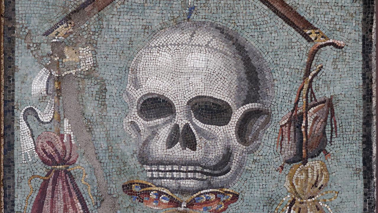 Sur ce détail d'une mosaïque romaine, on distingue plusieurs symboles. Une étoffe pourpre, à gauche, représente la richesse alors que la peau de chèvre, à droite, symbolise la pauvreté. Au centre, la Mort est aux aguets. Lorsqu'elle survient, l'âme (symbolisée par le papillon) s'envole.