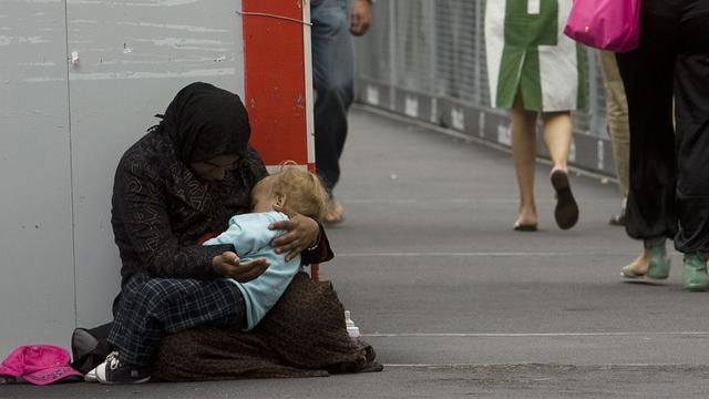Une mendiante avec un enfant, sur le Pont de la Machine, à Genève. [keystone]