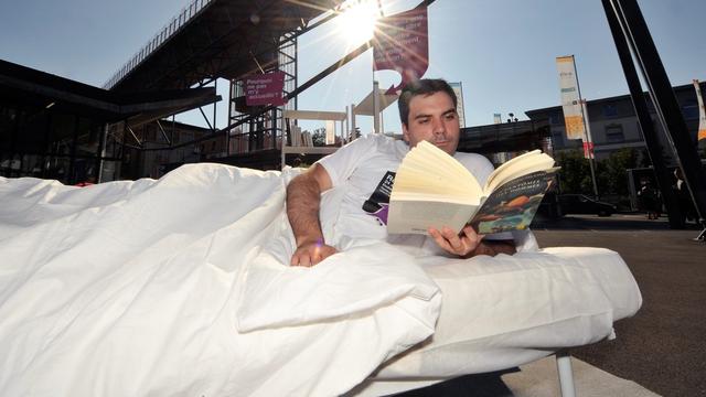 Un étudiant pose dans une chambre a coucher reconstituée au centre de Lausanne pour sensibiliser la population à la pénurie de logement.
dominic favre
keystone [dominic favre]