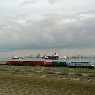 Vue sur le port de Rotterdam, entre cargos maritimes et convois de conteneurs. [RTS - Henry Buxant]