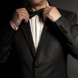 La tenue black tie comprend un smoking et un noeud de papillon noir. [fotolia - yurchello108]