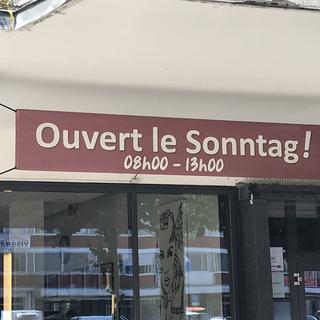 Une devanture de magasin mêlant français et allemand à Bienne (BE). [RTS - Philippe Girard]