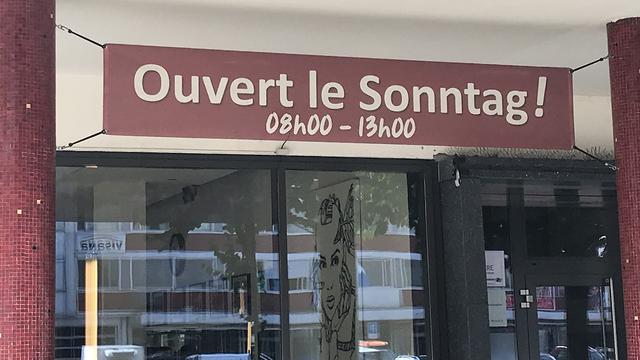 Une devanture de magasin mêlant français et allemand à Bienne (BE). [RTS - Philippe Girard]