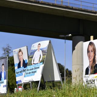 A l'approche des élections fédérales, les pancartes des candidats fleurissent en bordure de route. [Keystone - Walter Bieri]