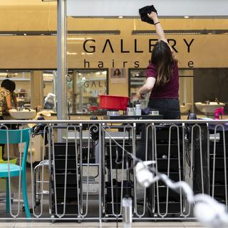 Eine Angestellte des Coiffeursalons Gallery Hairstyle reinigt die Fenster des Coiffeursalons, am Dienstag, 21. April 2020 in Bern. Coiffeure duerfen ihre Geschaefte ab dem 27.4.2020 wieder oeffnen. [KEYSTONE - Peter Klaunzer]