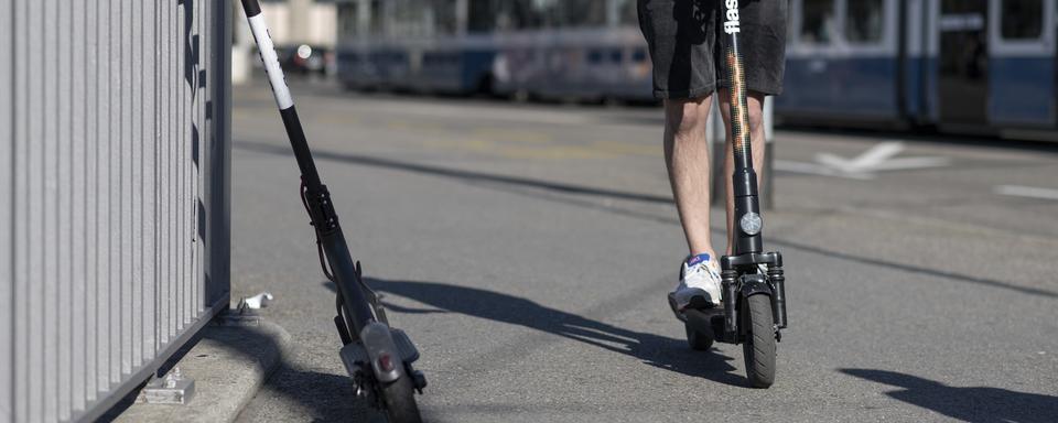 Un homme en trottinette électrique. [Keystone - Christian Beutler]