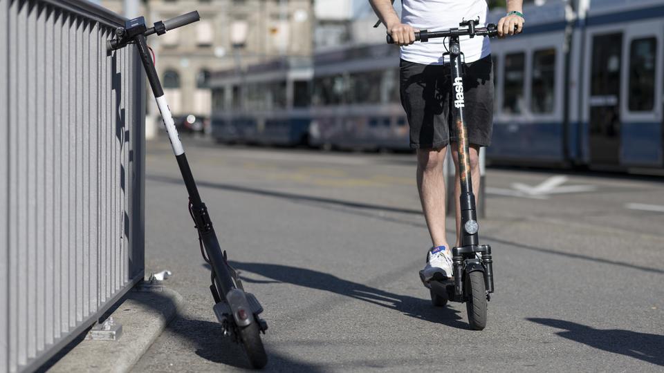 Un homme en trottinette électrique. [Keystone - Christian Beutler]