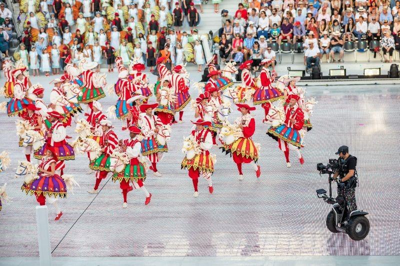 La troupe des Cent pour Cent dans une chorégraphie recréant un joyeux manège avec des petits chevaux. 100 hommes et 100 femmes. [RTS - Jay Louvion]