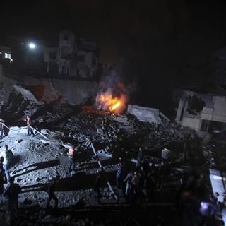 Des Palestiniens éteignent un feu après un raid israélien sur Gaza. [Reuters]