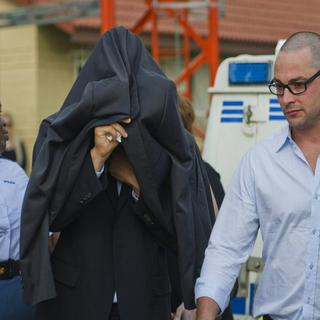 Oscar Pistorius, escorté par des policiers sur le chemin du tribunal, ce vendredi 15 février 2013. [AP/Keystone]
