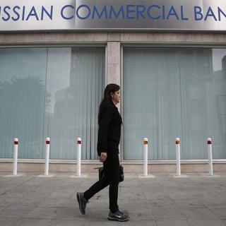 Une passante devant une banque russe à Nicosie (Chypre). [Yorgos Karahalis - Reuters]