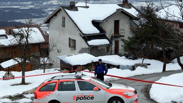 La police valaisanne stationnée devant la maison du forcené présumé. [Denis Balibouse - Reuters]