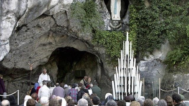 Des pèlerins priant devant la grotte de Lourdes. [Reuters]