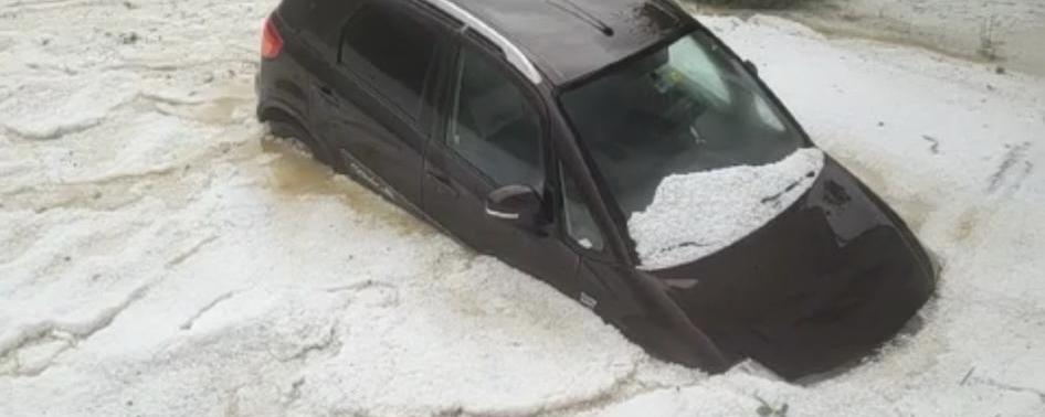 Une voiture sous l'eaux et les les grêlons, à Sonceboz, dans le Jura bernois. [Un habitant de Sonceboz (BE)]