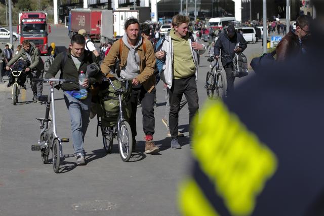 Un groupe de jeunes hommes russes traverse la frontière à Verkhniy Lars, en direction de la Géorgie, le mardi 27 septembre 2022. [KEYSTONE - ZURAB TSERTSVADZE]