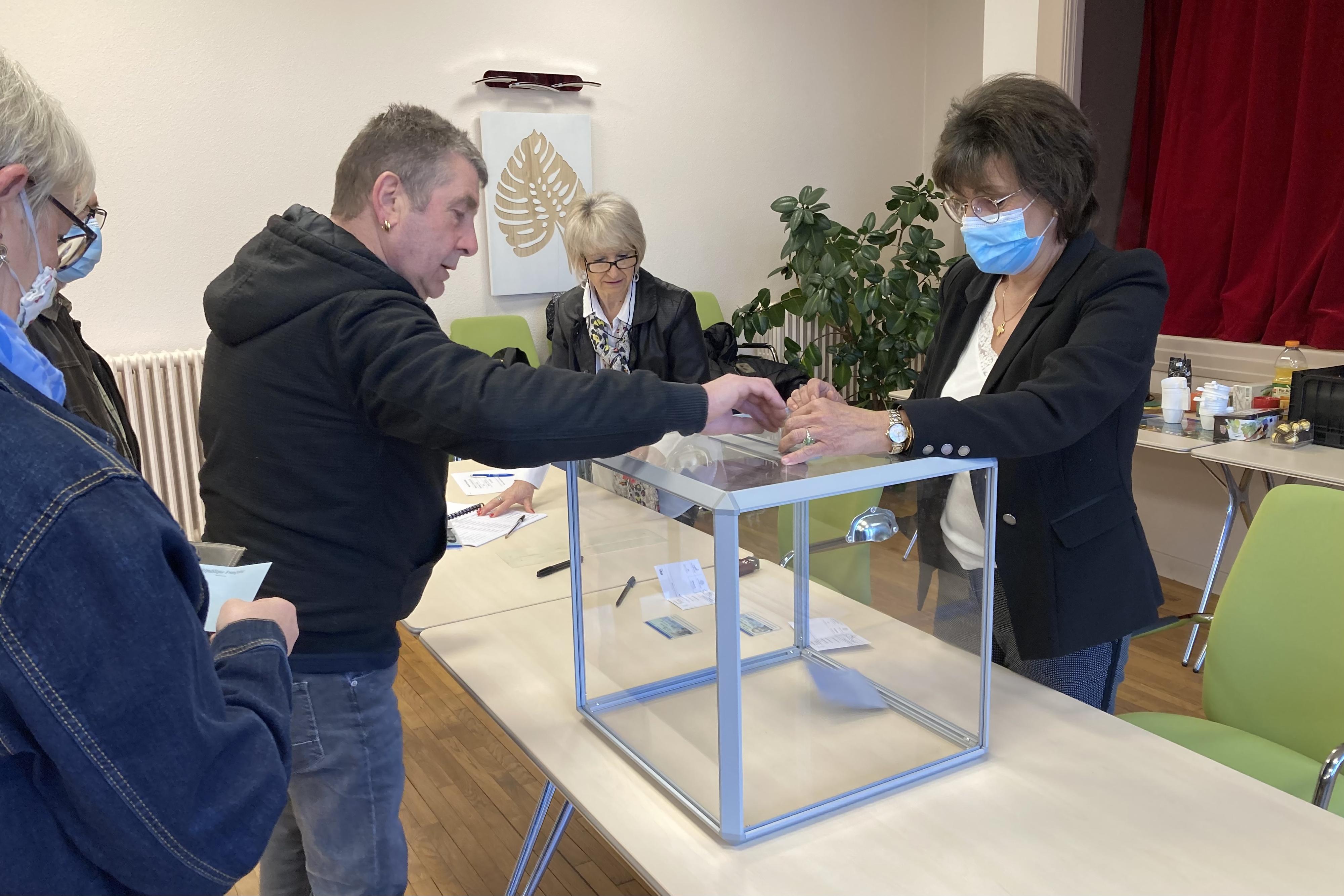 Un électeur dépose son bulletin dans l'urne de la commune de Morvillars, dans le Territoire de Belfort. [RTS - Gaël Klein]