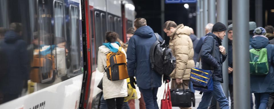 Des pendulaires montent dans un train à la gare de Bellinzone, le mercredi 6 décembre 2023. [Keystone - Francesca Agosta]