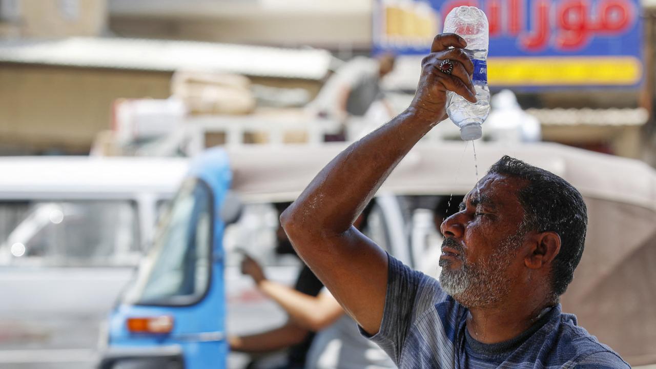 Un Irakien s'asperge le visage d'eau pour se rafraîchir pendant la canicule, dans le centre de Bagdad, le 13 août 2023. [AFP - Ahmad AL-RUBAYE]