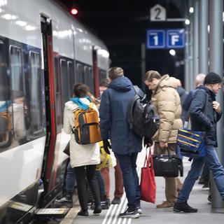 Des pendulaires montent dans un train à la gare de Bellinzone, le mercredi 6 décembre 2023. [Keystone - Francesca Agosta]