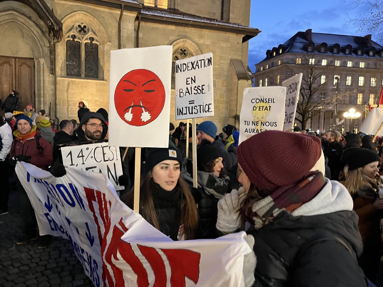 Manifestants avec un panneau critiquant la baisse de l'indexation. [RTS - Yoan Rithner]