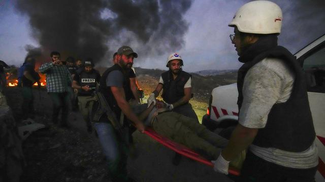 Des employés de la Défense civile transportent Elie Brakhya, caméraman de la télévision qatarie d'Al-Jazeera, qui a été blessé par les bombardements israéliens, dans le village frontalier d'Alma al-Shaab avec Israël, au sud du Liban, le vendredi 13 octobre 2023. [Keystone - Hassan Amar]