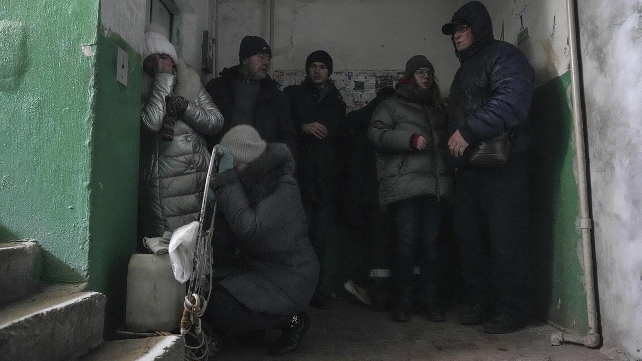 Des personnes se protègent lors d'un bombardement à Marioupol, le 13 mars 2022. [Keystone - AP Photo/Evgeniy Maloletka]