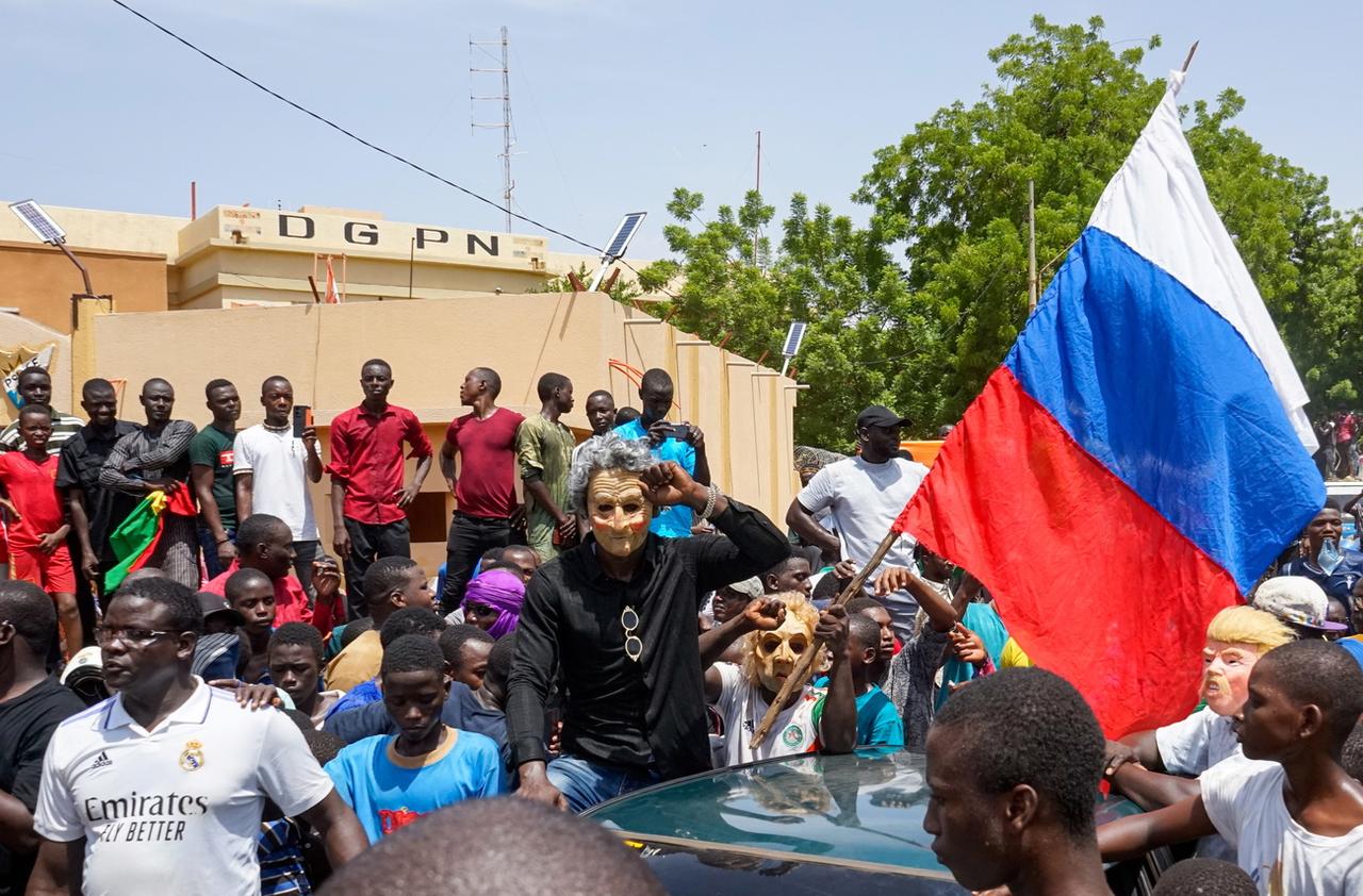 Des manifestants déploient un drapeau russe devant le bâtiment de l'Assemblée nationale lors d'une manifestation à Niamey, le 30 juillet 2023. [Keystone - Issifou Djibo]