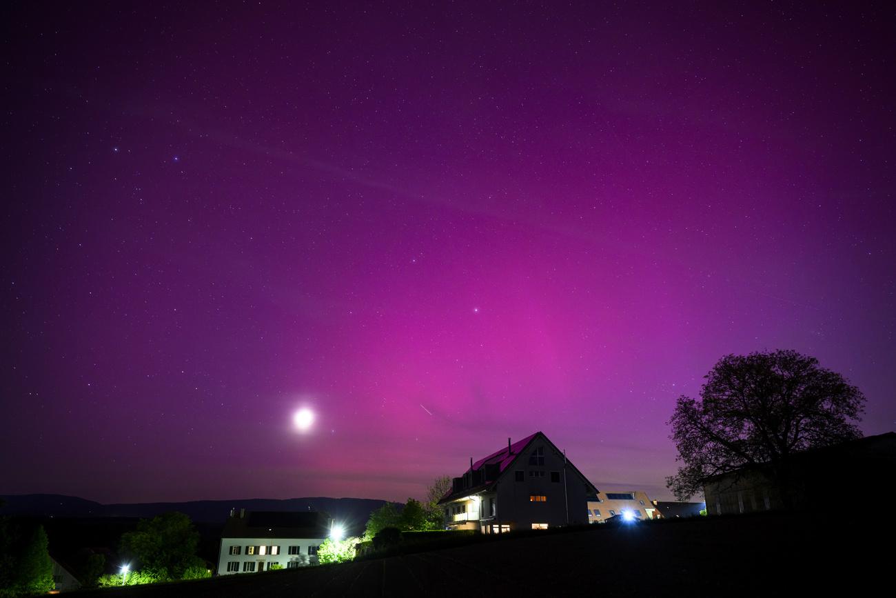 Une aurore boréale observée dans le ciel du village de Daillens (VD), le vendredi 10 mai 2024. [KEYSTONE - LAURENT GILLIERON]