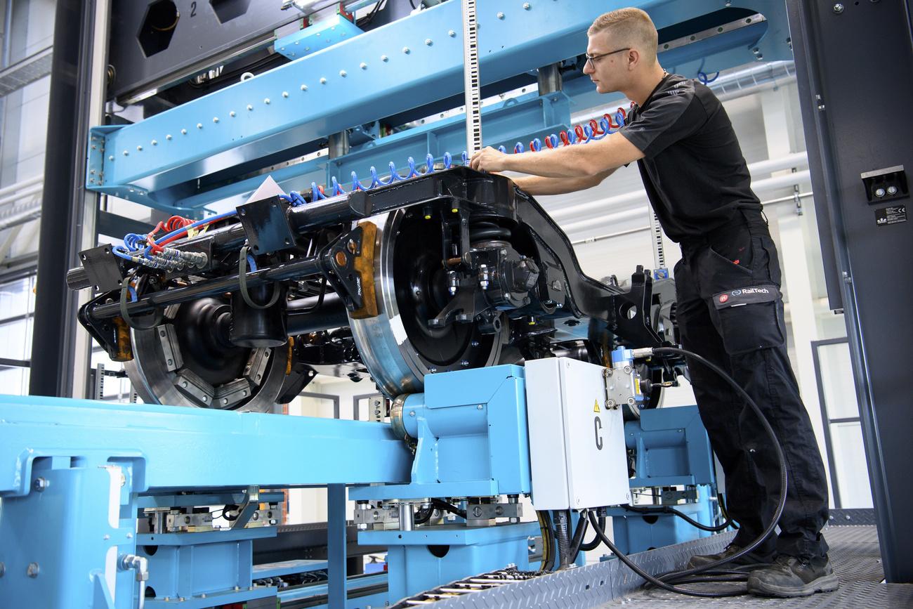 Un employé travaille à l'entretien d'un bogie dans le centre romand d'entretien des bogies RailTech à Villeneuve. [KEYSTONE - LAURENT GILLIERON]