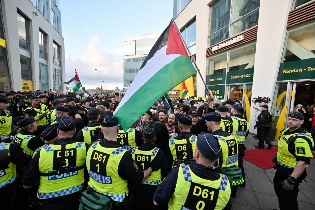 Des manifestants pro-palestiniens font face à la police devant le Malmö Arena avant la finale du 68e Concours Eurovision de la chanson, le 11 mai 2024. [AFP - JOHAN NILSSON]