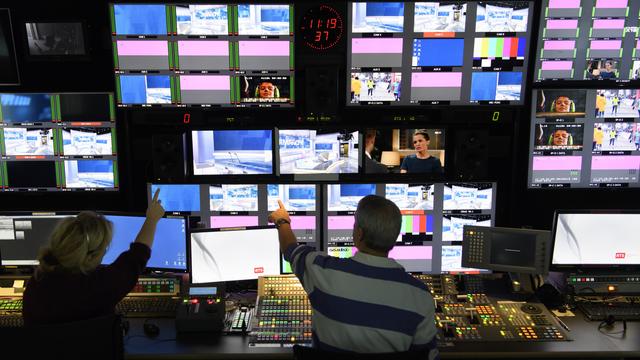 Un réalisateur et une technicienne travaillent dans la régie du studio RTS Sport au siège de la Radio Télévision Suisse, à Geneve. [KEYSTONE - LAURENT GILLIERON]