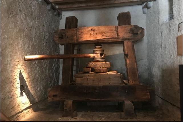 Un ancien pressoir à raisin, dans les caves du château d'Aigle. [Swissinfo.ch]