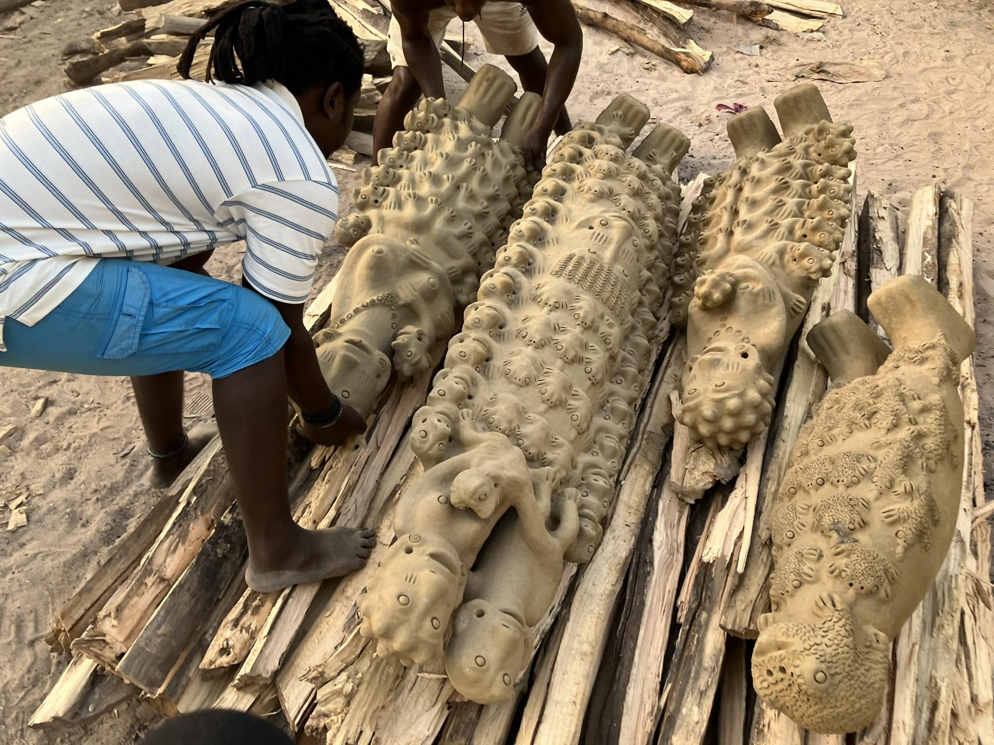 Les beaux-fils de Seyni Awa Camara, Baba Ghali, Aliou et ici Ibrahima Diallo, construisent le bûcher avec les pièces à cuire. [RTS - Francesco Biamonte]