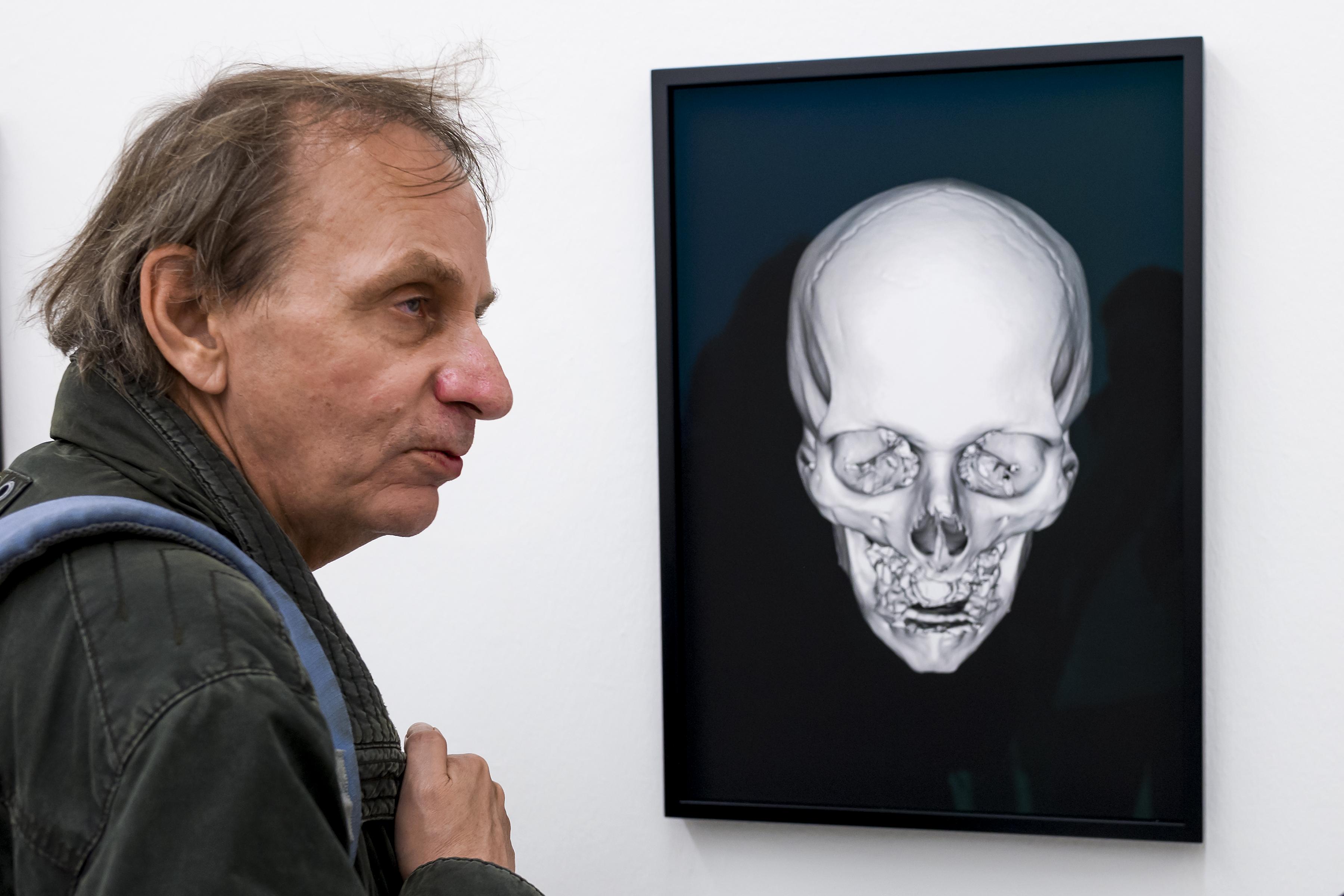 Michel Houellebecq, près d'une oeuvre qui représente la radiographie de son crâne lors de Manifesta 11. [AFP - Fabrice Coffrini]