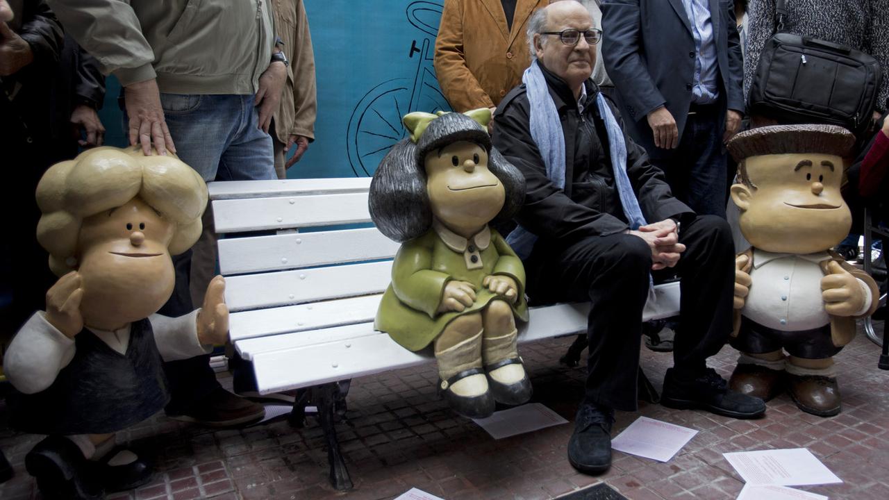 Le dessinateur Quino, photographié ici aux côté de son personnage phare Mafalda, est décédé mercredi à l'âge de 88 ans. [Keystone - Jose Luis Cereijido]