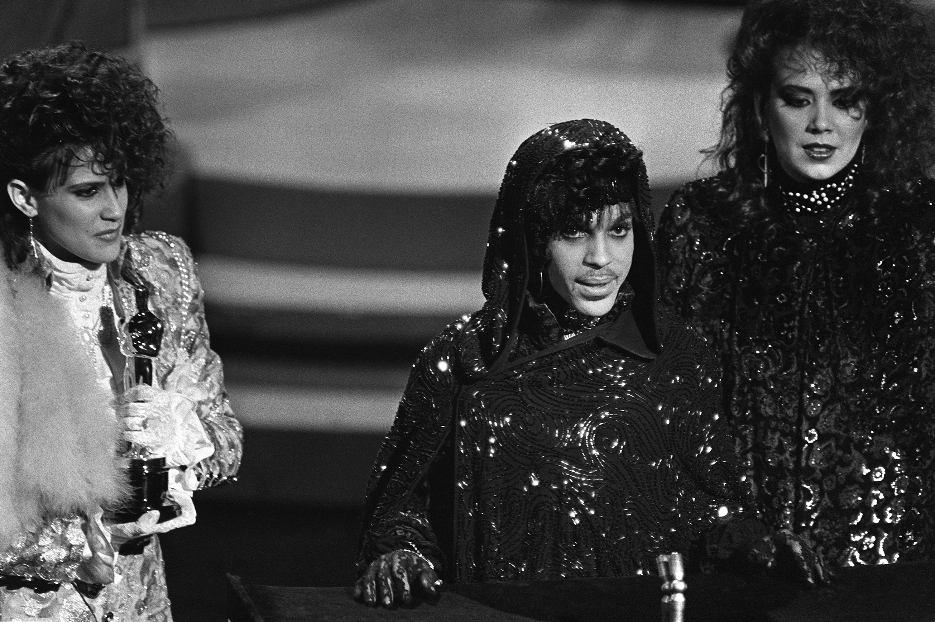 Le chanteur américain Prince,  reçoit l'oscar de la meilleure partition originale, pour "Purple Rain", lors de la 57e remise des Oscars à Hollywood, le 25 mars 1985. [harms/AFP - HARMS]