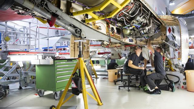 Deux mécaniciens de Ruag travaillent sur un F/A-18. [Keystone - Peter Klaunzer]