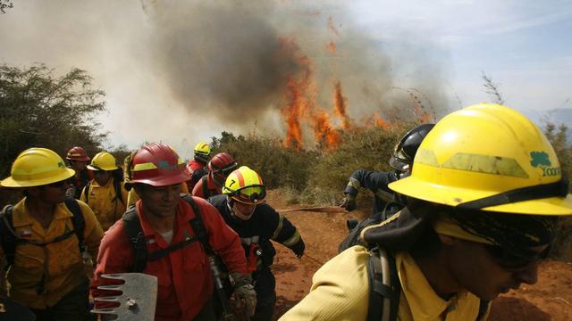 Sept unités de pompiers combattent le feu à Valparaiso. [Keystone - Humberto Gomez]