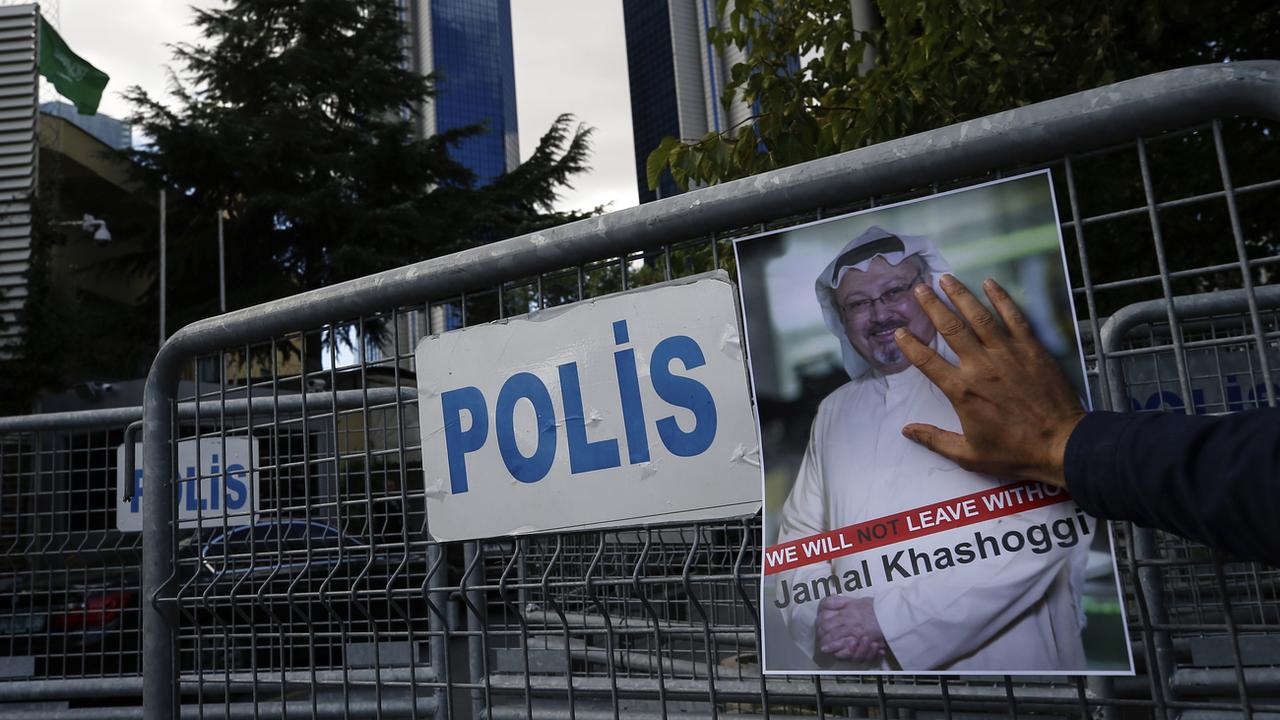 Un poster de Jamal Khashoggi devant les barrières bloquant la route menant au consulat d'Arabie Saoudite à Istanbul. [Keystone - AP Photo/Emrah Gurel]