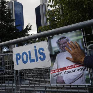 Un poster de Jamal Khashoggi devant les barrières bloquant la route menant au consulat d'Arabie Saoudite à Istanbul. [Keystone - AP Photo/Emrah Gurel]