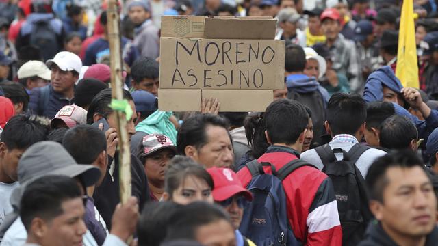 Un protestant antigouvernement tient un panneau avec inscrit en espagnol "Moreno Assassin". [AP Photo - Dolores Ochoa]