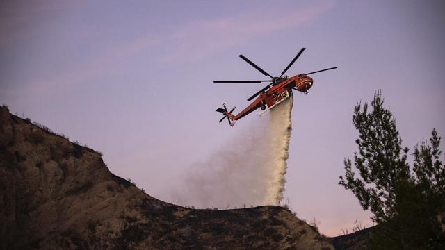 Un hélicoptère déverse de l'eau pour tenter de contenir les feux près de Santa Clarita en Californie. [EPA - Etienne Laurent]