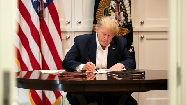 Donald Trump travaille en costume présidentiel tout en recevant un traitement contre le Covid-19. [Reuters - Joyce N. Boghosia/The White House]