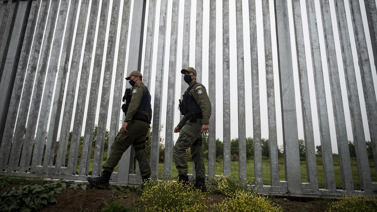 Des policiers patrouillent le long d'un mur à la frontière entre la Grèce et la Turquie. [AP Photo - Giannis Papanikos]