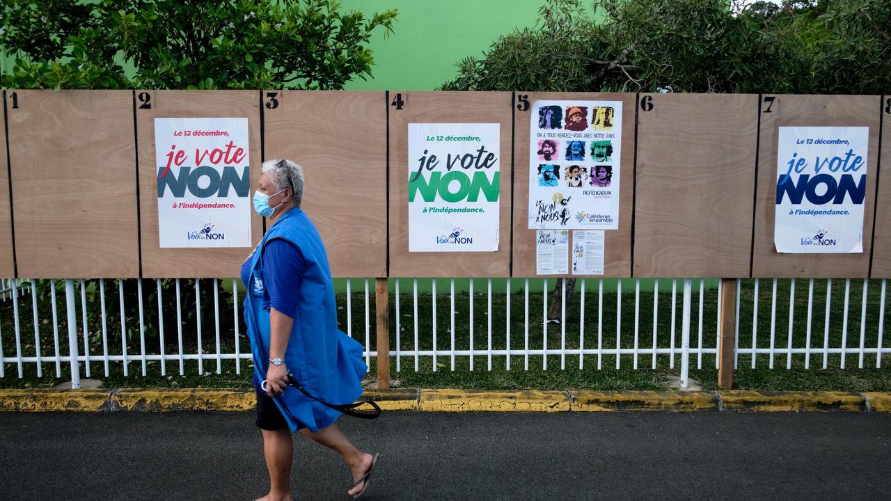 Une femme passe devant des affiches électorales pour le vote sur l'indépendance de la  Nouvelle-Calédonie. [AFP - Theo Rouby]